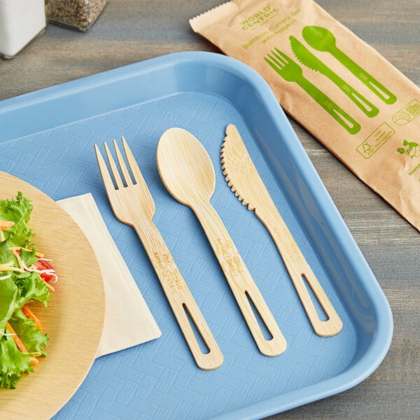 A blue tray with wrapped compostable bamboo cutlery and a napkin on it.