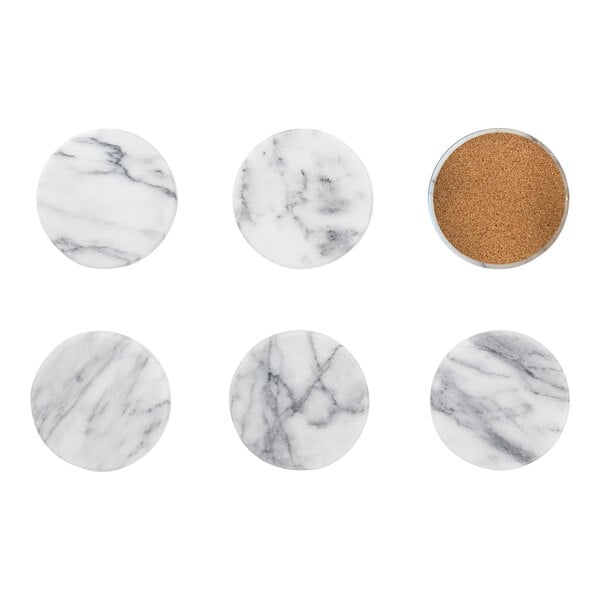 A group of white marble coasters with black veins on a white marble surface.