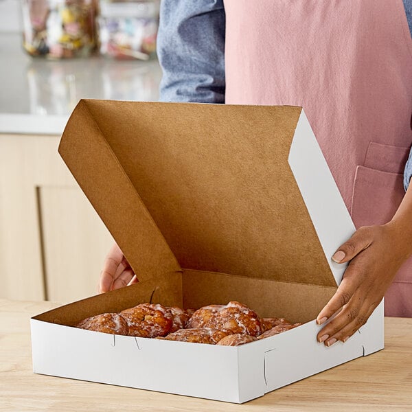 A woman holding a Southern Champion white pie box full of food.