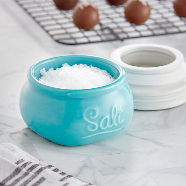 A blue and white ceramic salt cellar with salt in it.