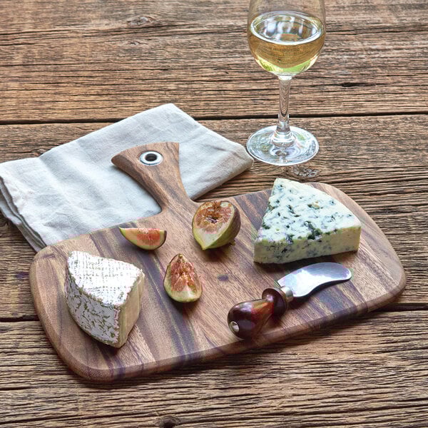 An Ironwood acacia wood paddle board with cheese, figs, and a glass of wine.