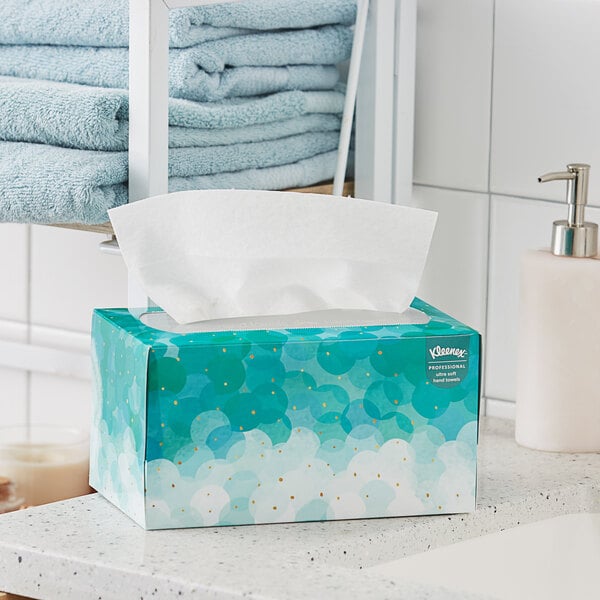 A Kleenex Professional white paper hand towel pop-up box on a white counter.