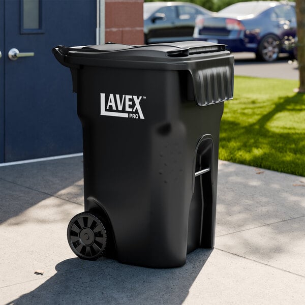 A large black rectangular wheeled trash can with a lid labeled 'Lavex Pro'.