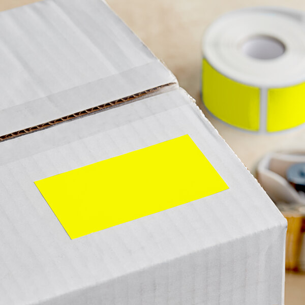 A white box with a roll of bright yellow Lavex inventory labels.