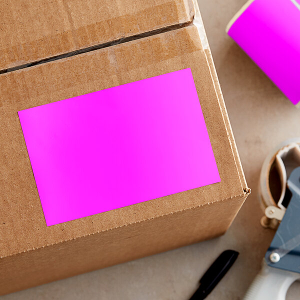 A cardboard box with a rectangular pink label on it.