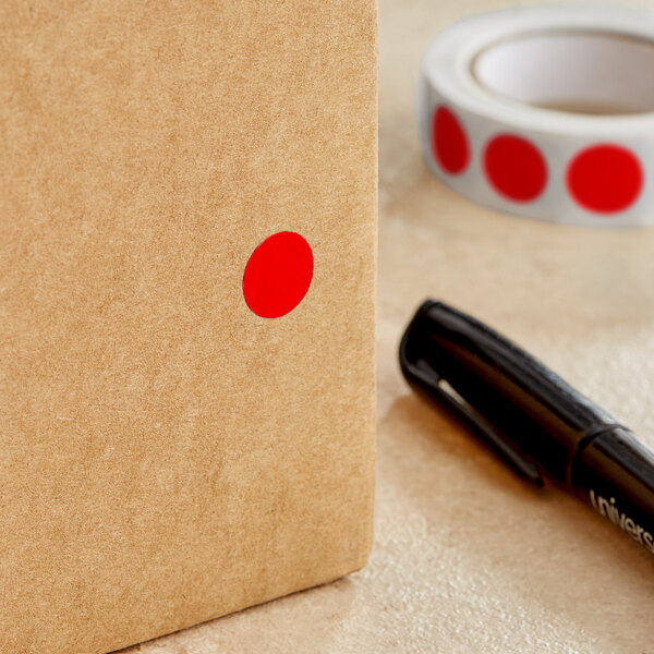 A roll of Lavex red round inventory labels with a red dot on a brown surface.