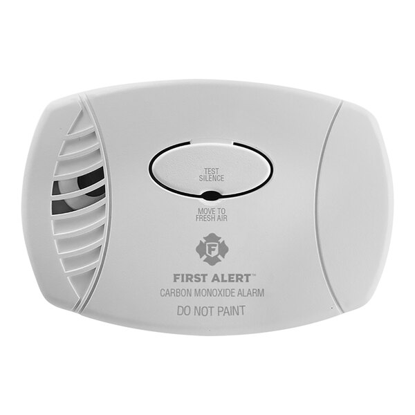 A white First Alert plug-in carbon monoxide alarm with a round button.