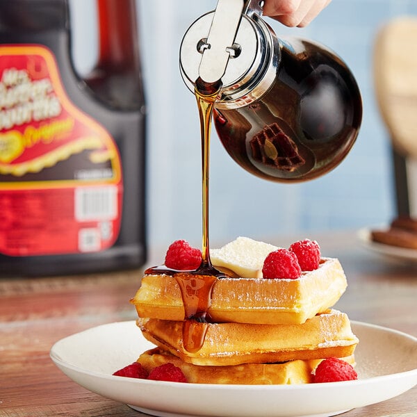 A person pouring Mrs. Butterworth's Original Breakfast Syrup on a stack of waffles.