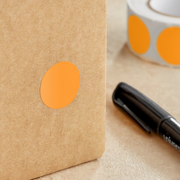 A roll of Lavex fluorescent orange paper circle stickers with a black pen.