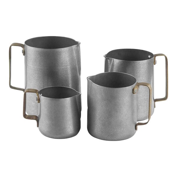 A close-up of a Tablecraft stainless steel frothing pitcher with a gold handle.