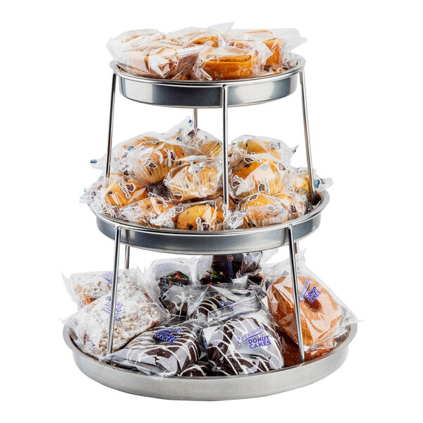 A Tablecraft 3-tier stainless steel sharing tower holding a bag of donuts on a counter.