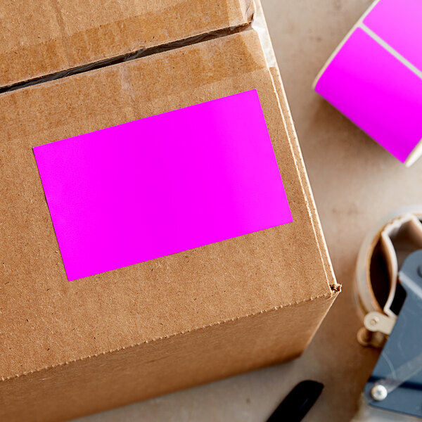 A cardboard box with a pink rectangular sticker on it.