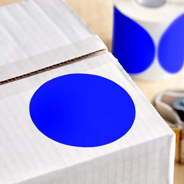 A white box with a roll of dark blue paper labels with blue circles on them.