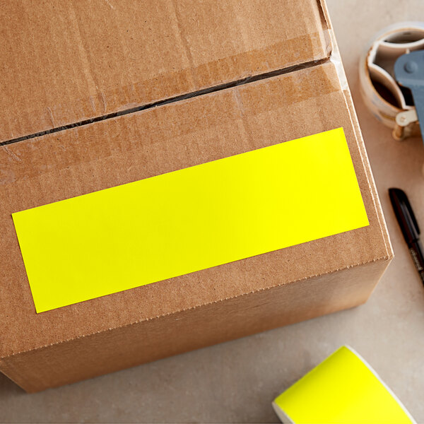 A Lavex bright yellow rectangular inventory label on a cardboard box.