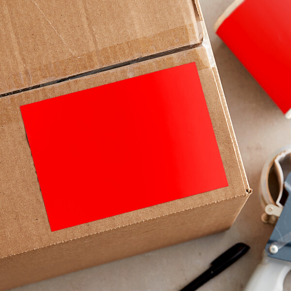 A cardboard box with a close-up of a red rectangular label.