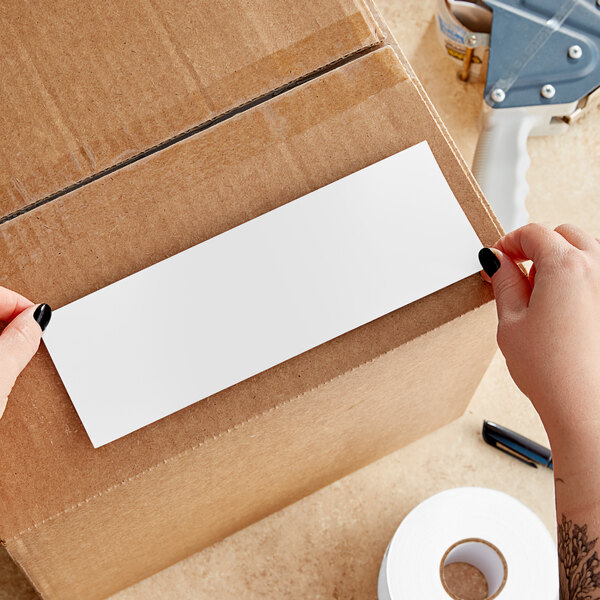 A person's hands holding a white rectangular piece of paper.