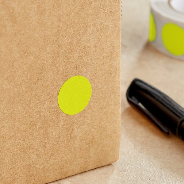 A brown box with a Lavex Chartreuse round inventory label with a yellow dot on it.