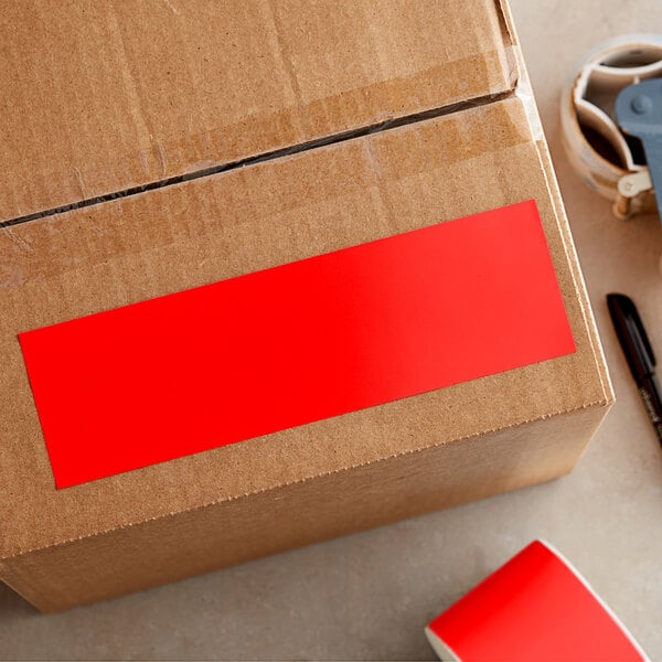 A cardboard box with a red rectangular label reading "Lavex Fluorescent Red Inventory Label"