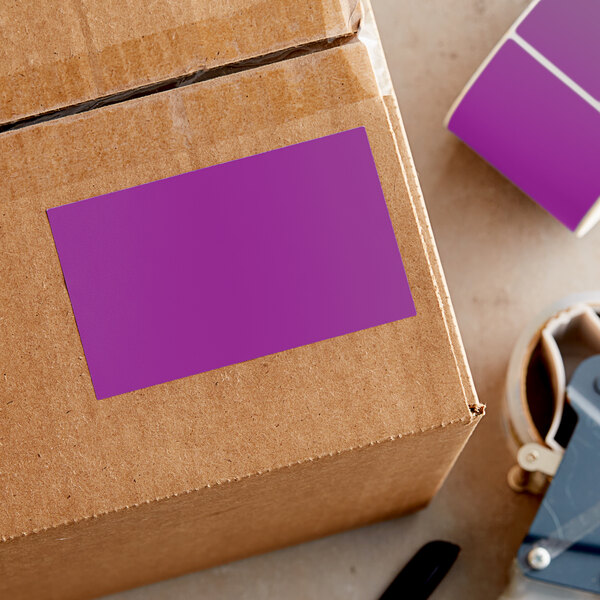 A purple rectangular sticker on a cardboard box.