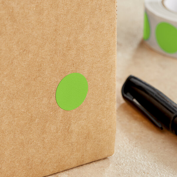 A brown box with a green round sticker with white text on it.