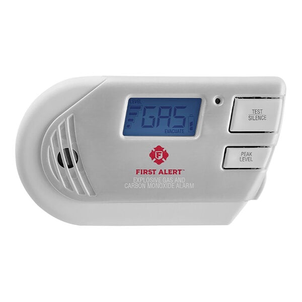 A white First Alert plug-in carbon monoxide and explosive gas alarm with a blue digital display.