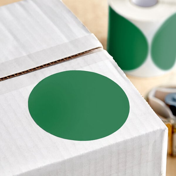 A white box with a green circle on it containing a roll of green and white Lavex Inventory labels.