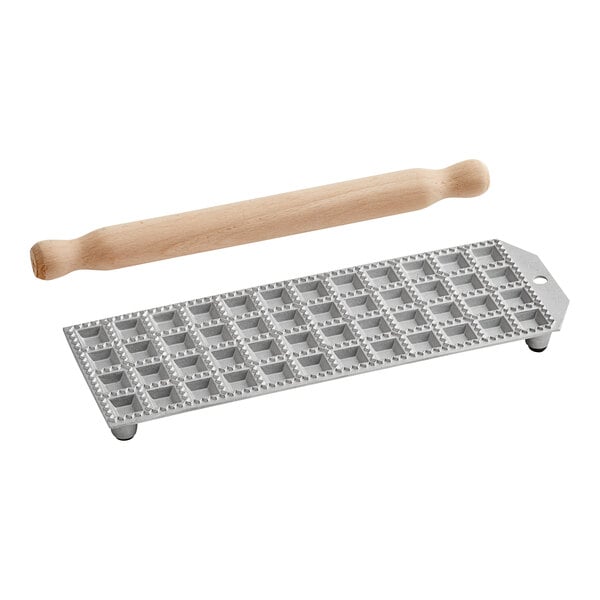 A grey rectangular Imperia ravioli mold with square holes and a rolling pin.