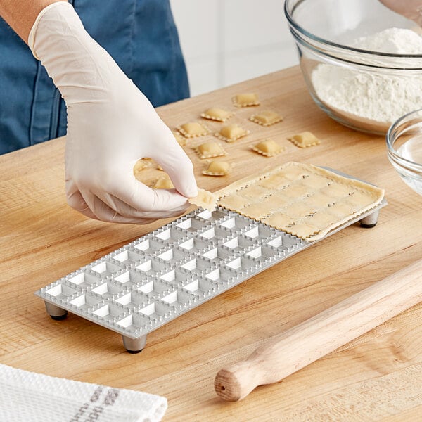 A person using the Imperia RavioChef ravioli mold to make ravioli.