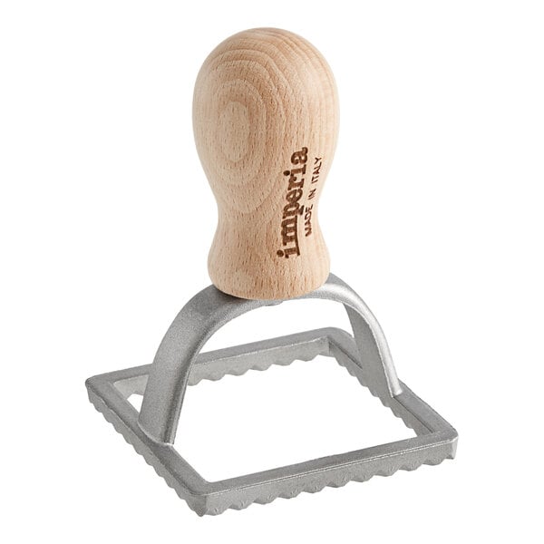 An Imperia square ravioli cutter stamp with a wooden handle and metal stamp.