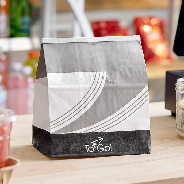 A Bagcraft white meal bag with a rectangular black and white label sitting on a counter.