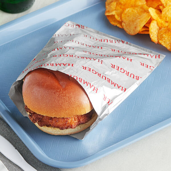 A Bagcraft printed foil hamburger bag with a burger and potato chips on a tray.