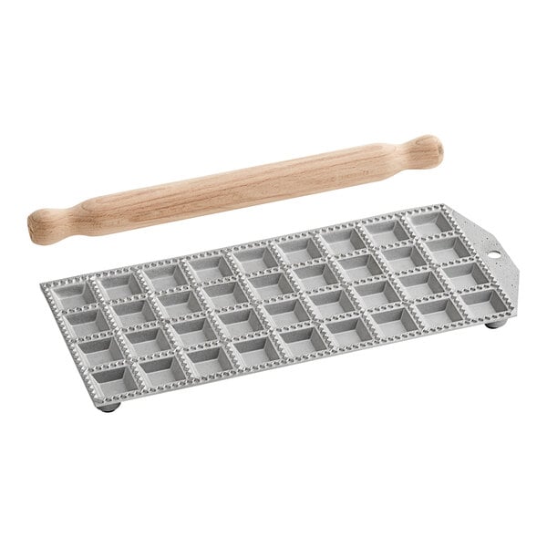 A white Imperia tray with a rolling pin and a wooden handle with a mold for ravioli.