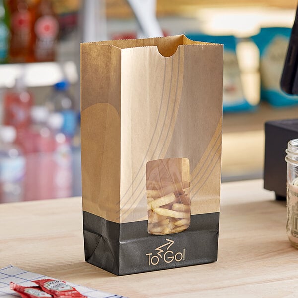 A Bagcraft EcoCraft printed meal bag on a table with a bag of french fries inside.