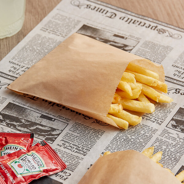 A natural brown Bagcraft EcoCraft french fry bag on a table with french fries in it.