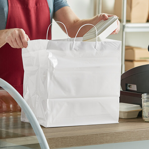 A person holding a white Innopak plastic shopper bag.