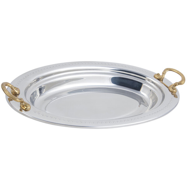 A stainless steel Bon Chef oval food pan with round brass handles.