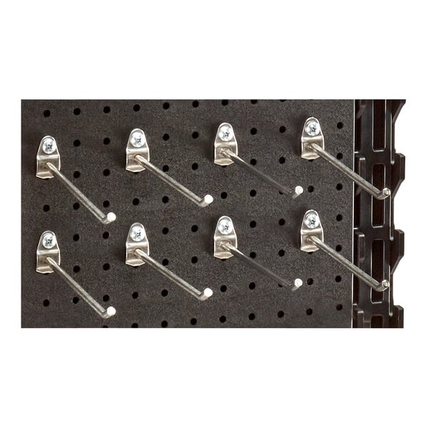 A group of stainless steel pegboard hooks on a black pegboard.