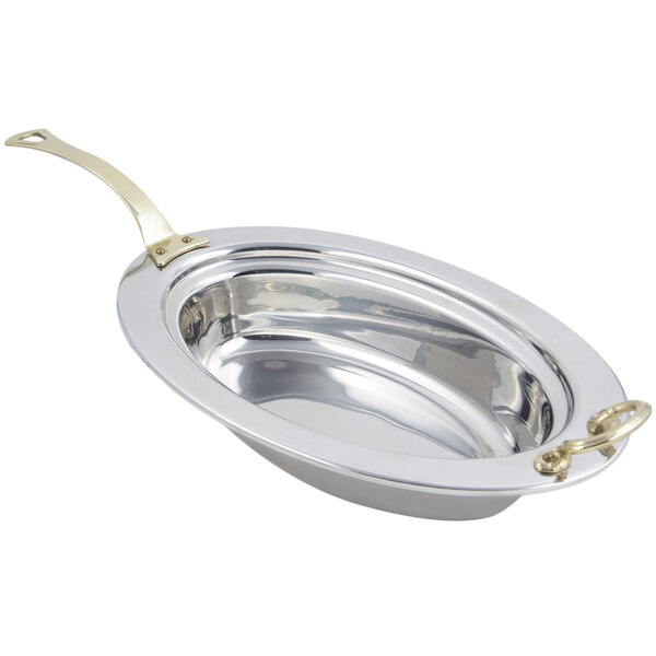 A large silver stainless steel oval food pan with a long brass handle.