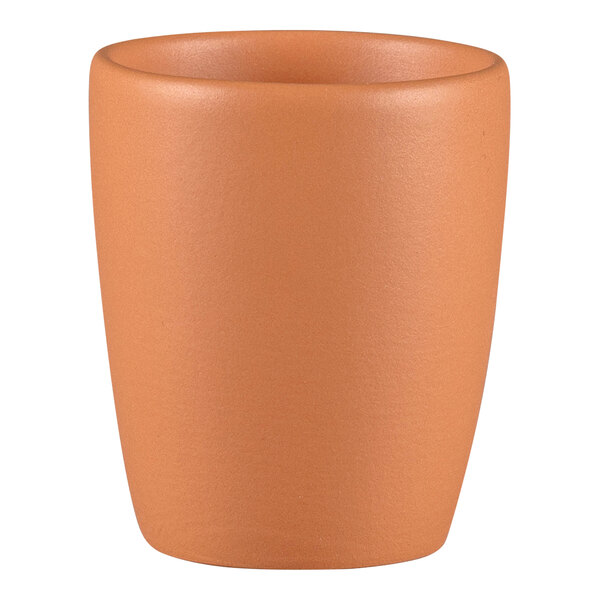 A close up of a RAK Porcelain Terra Cotta espresso cup with no handle on a white background.