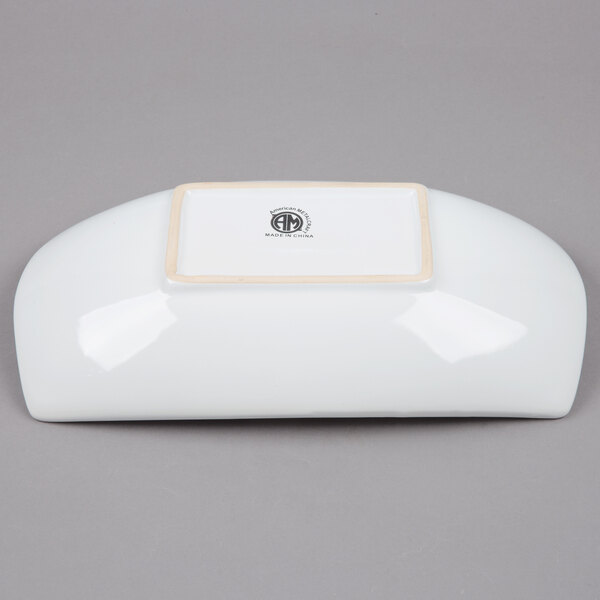 An American Metalcraft stoneware oval serving bowl with a white border and a logo on it.