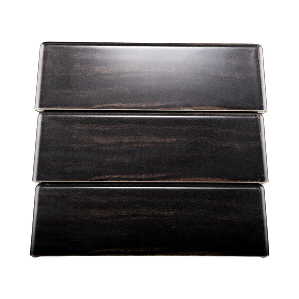 A close up of a black and brown rectangular faux zebra wood panel.