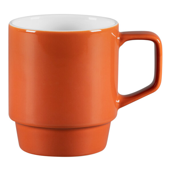 A close-up of a matte brown porcelain mug with a white handle.