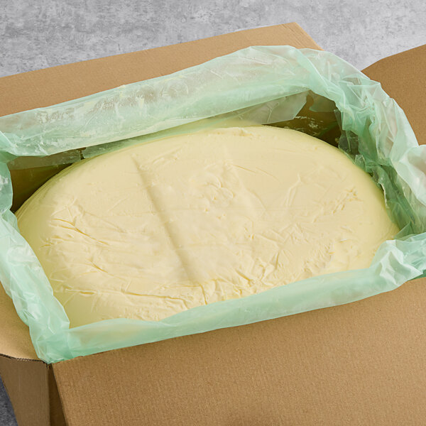 A large round white object in a plastic wrap in a box.