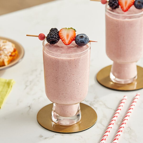 Two glasses of pink Maui by Lyons Wild Berry Acai smoothie with straws and berries.