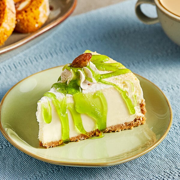 A slice of cheesecake with Lyons Kiwi Lime flavoring sauce on top.