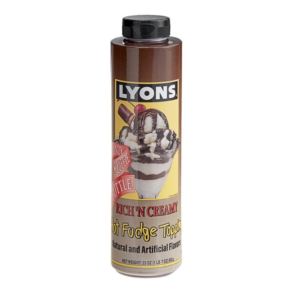 A bottle of Lyons Rich N' Creamy Chocolate Hot Fudge Topping on a counter near ice cream.
