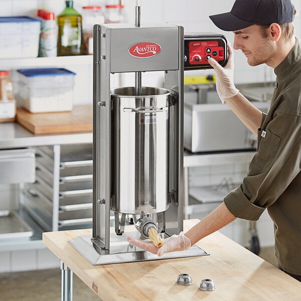 A man using a stainless steel Avantco churro stuffer.