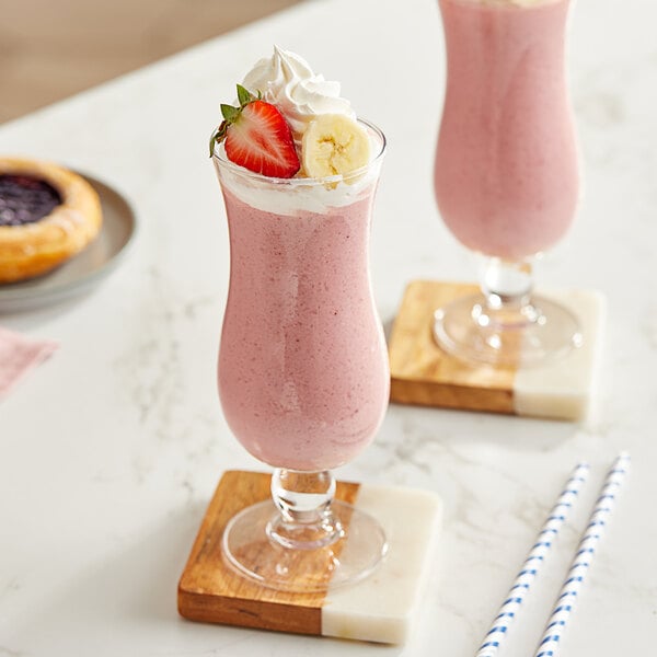 Two glasses of pink Maui by Lyons strawberry banana smoothie on a table.