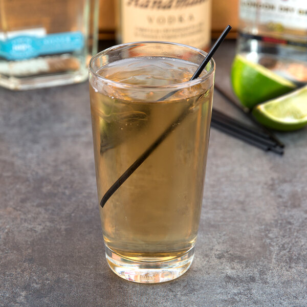 A Libbey highball glass filled with a drink and a straw.