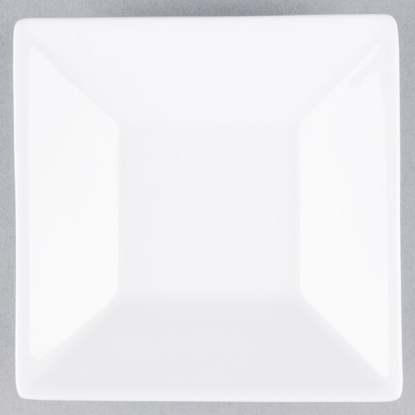 A white square porcelain saucer with a well ring.